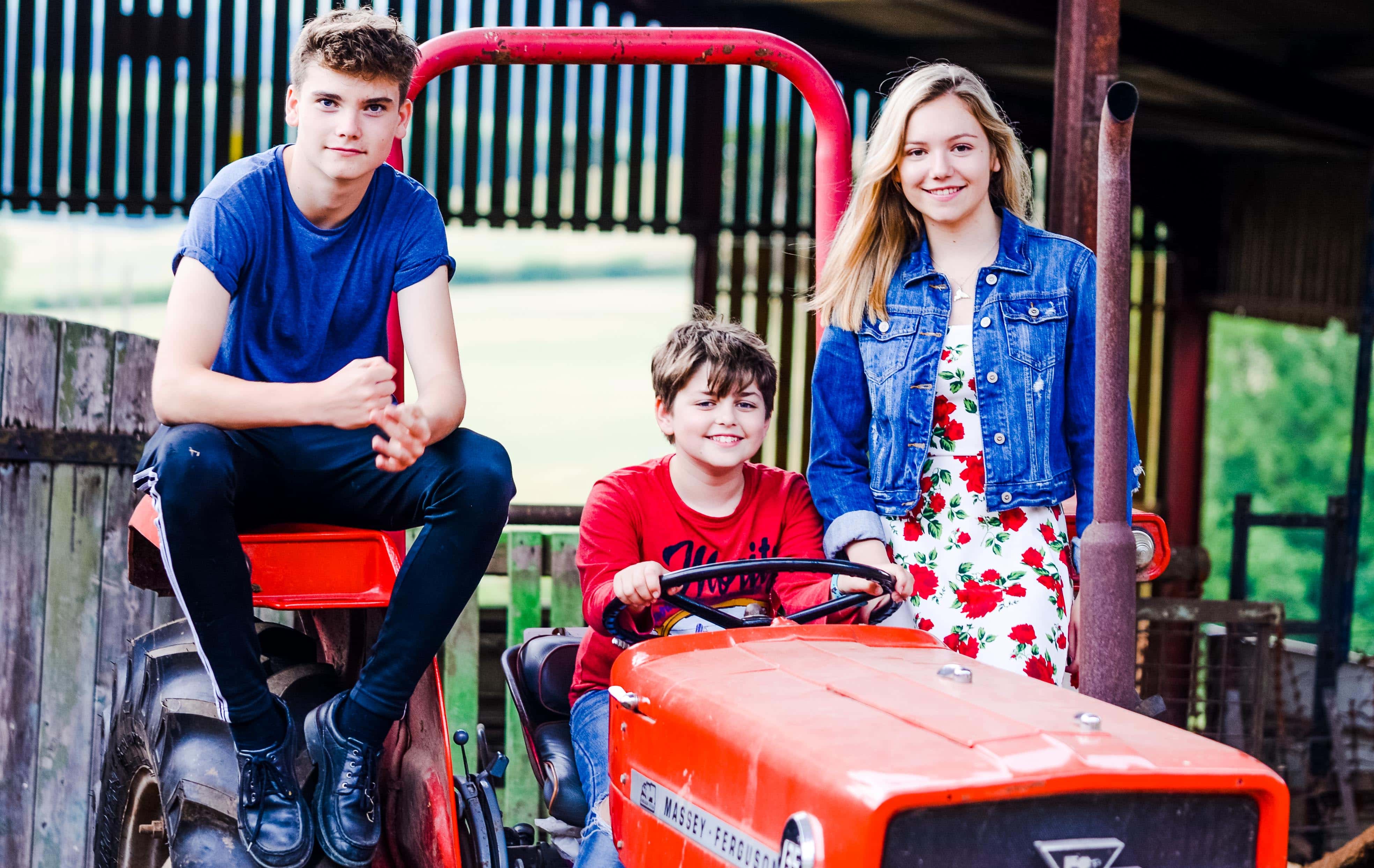 Family photo taken on farm with tractor and trailer in Worcestershire
