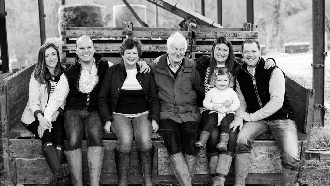 Family with three generations sitting on trailer during family photo session on farm in Worcestershire by Michelle Morris