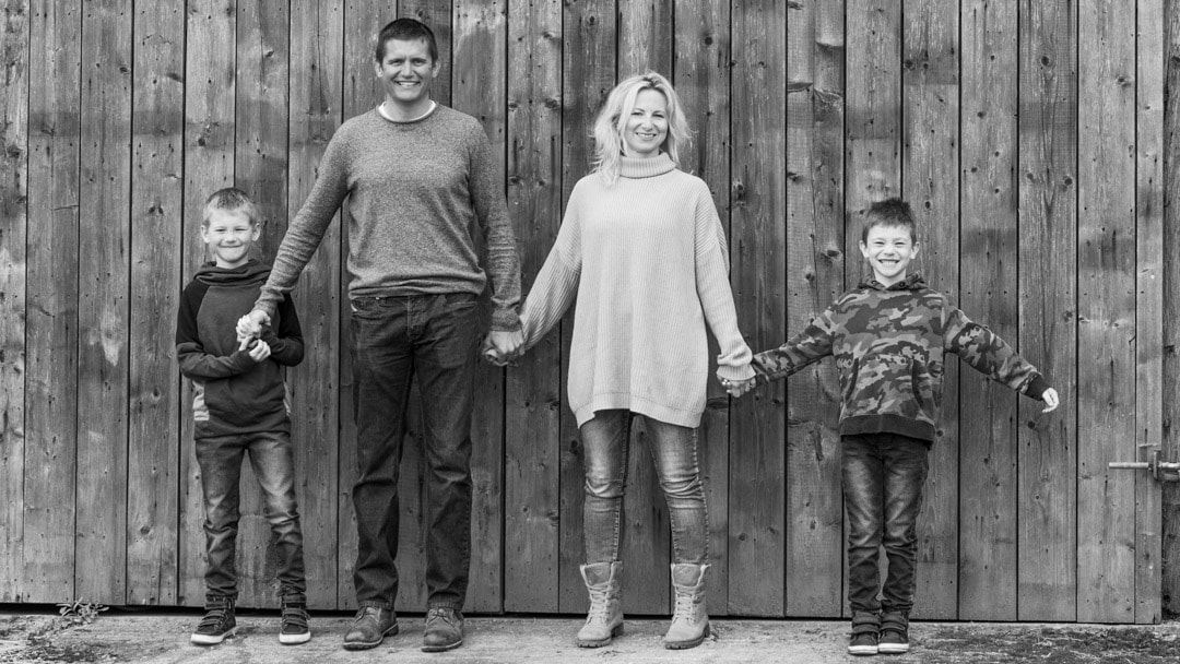 Family photo in front of barn door on farm in Worcestershire by Michelle Morris